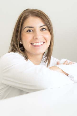 Hochformatiges Portrait einer Patientin, die freundlich in die Kamera lächelt und Vertrauen ausstrahlt.